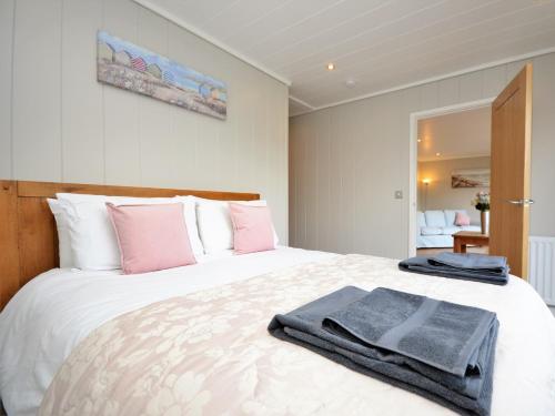 - une chambre avec un grand lit blanc et des oreillers roses dans l'établissement 1 Bed in Conwy 60294, à Llangelynin