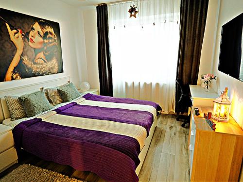 sypialnia z fioletowym łóżkiem i dużym oknem w obiekcie Relaxing Coresi Place w Braszowie