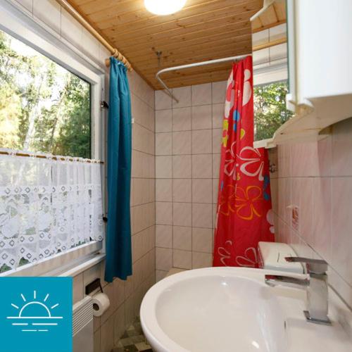 baño con aseo y lavabo y ventana en Bungalow SONNE UND MEER direkt am Strand en Dranske