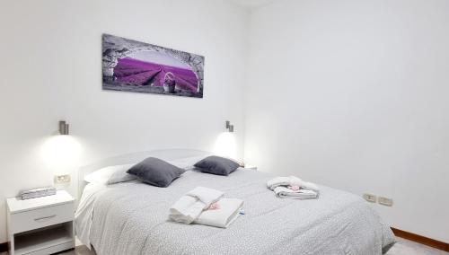 una camera da letto con un letto bianco con due asciugamani di GUEST HOLIDAY BETTOLA a Reggio Emilia