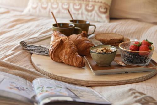 een ontbijtpakket met croissants en fruit op een bed bij Smuk Grutte Bell Tent in Echtenerbrug