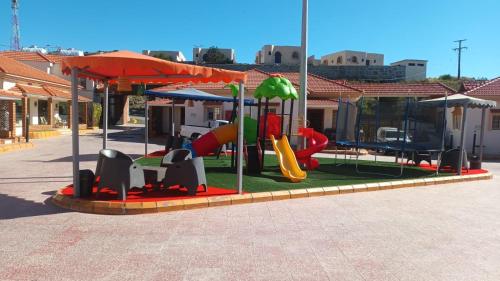 a playground with a slide and a play equipment at شاليهات وفلل قاردن سيتي in Baljurashi