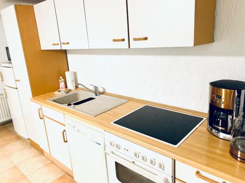 a kitchen with a sink and a stove top oven at Souterrain Monteurwohnung mit Sauna und Garten in Rostock