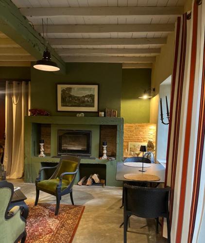 a living room with a fireplace and a bed at Le Clos de Mara in Issus