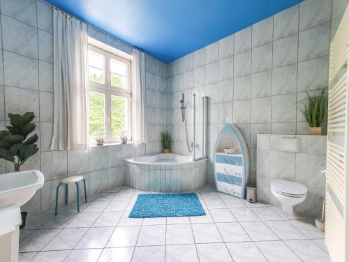 a bathroom with a tub and a toilet and a sink at DEUTSCHE VILLA - DELUXE APARTMENT mit Sauna und großem Garten in Rostock