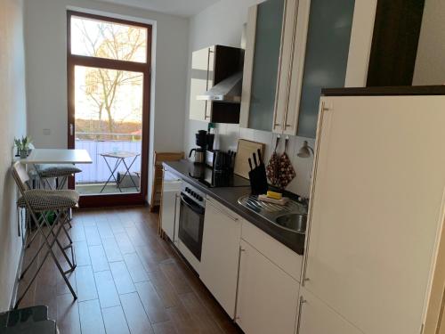 eine Küche mit einem weißen Kühlschrank und einer Spüle in der Unterkunft Traumwohnung STÖRTEBEKER ruhig & großzügig zentral in Rostock
