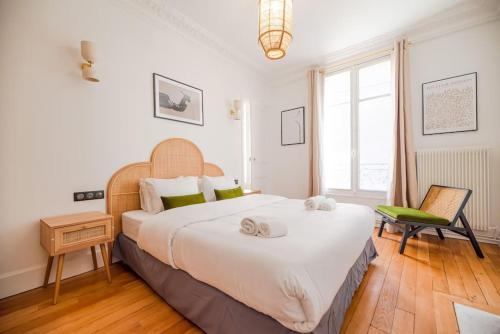 une chambre avec un grand lit et une chaise dans l'établissement Vignature REIMS - Cathédrale, à Reims
