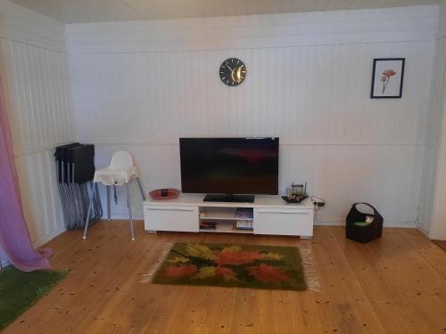 a living room with a flat screen tv on a white wall at Hemtrevlig villa i Billingsfors in Billingsfors