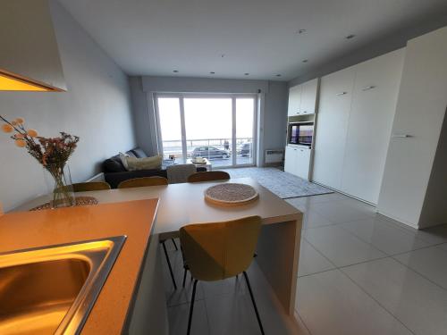 a kitchen and living room with a table and chairs at 'Aurore' - Romantic Studio with Seaview in Ostend