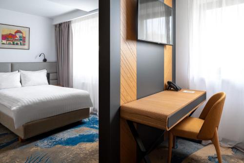 a bedroom with a bed and a desk with a bed and a deskuggest at Alexandrion Experience in Sinaia