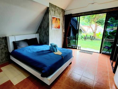 a bedroom with a bed with a blue comforter at Cashewnut Tree Resort in Ko Lanta