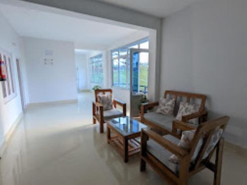 a living room with two chairs and a table at Hotel Dewa Elegance Tawang in Tawang