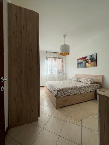 Schlafzimmer mit einem Bett und einer Holztür in der Unterkunft Elegante Casa -Rho Fiera in Vanzago