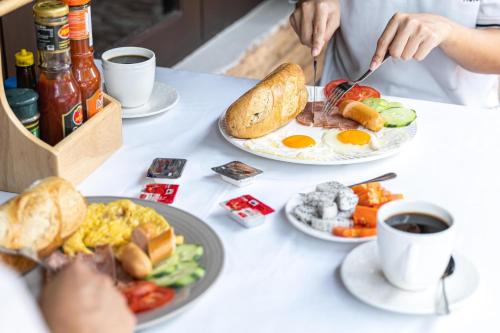 - une table avec des assiettes de produits pour le petit-déjeuner et du café dans l'établissement Vongkhamsene Boutique Hotel, à Ban Nongdouang