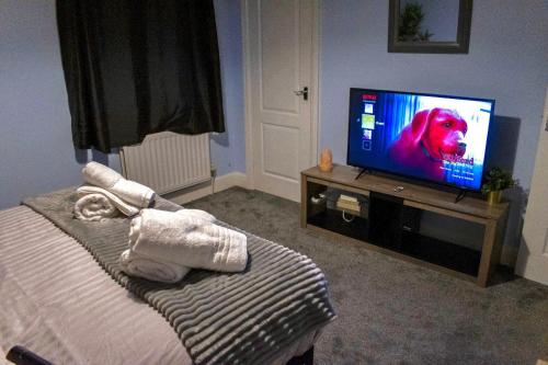 a bedroom with a television with a dog on the screen at Watford Cozy Full Home W Parking - Perfect for Harry Potter Studios! in Leavesden Green
