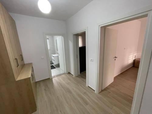 ein leeres weißes Zimmer mit einem Flur mit einem Spiegel in der Unterkunft Kevi ‘s place in Tirana