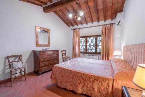 a bedroom with a bed and a dresser and a window at Le Masse in Greve in Chianti
