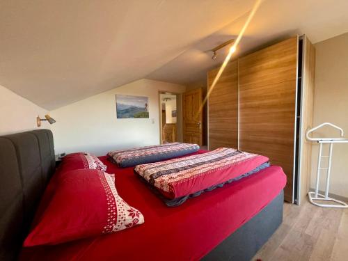 1 dormitorio con 2 camas con sábanas rojas. en Im- Oberland - Berg - KönigsCard en Bad Kohlgrub