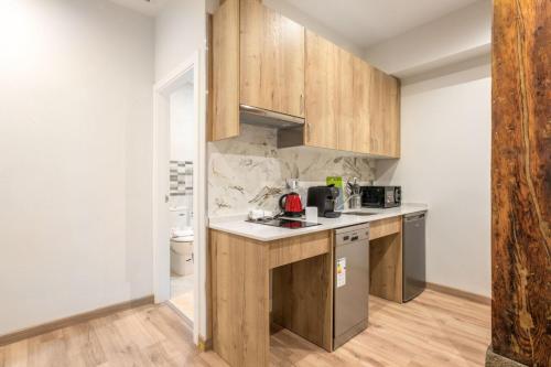 uma cozinha com armários de madeira e uma bancada em 1 bedroom 1 bathroom furnished - Justicia - Cozy - MintyStay em Madri