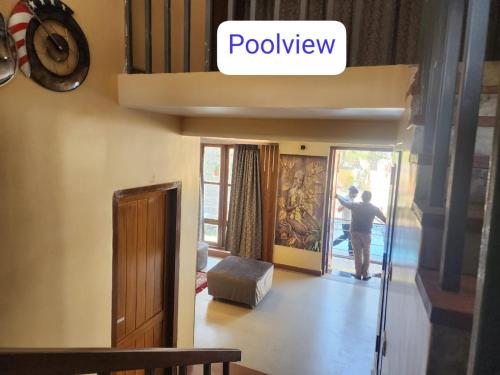 a man opening the door to a living room at Richak Ganges villa in Kolkata