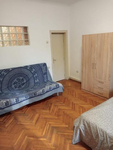 a bedroom with a bed and a wooden floor at Romana City Center Studio in Bucharest