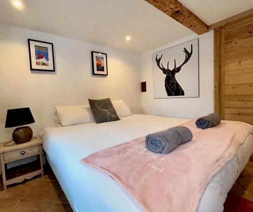 a bedroom with two beds and a deer picture on the wall at Gorgeous Mini-Chalet Chamonix in Chamonix-Mont-Blanc
