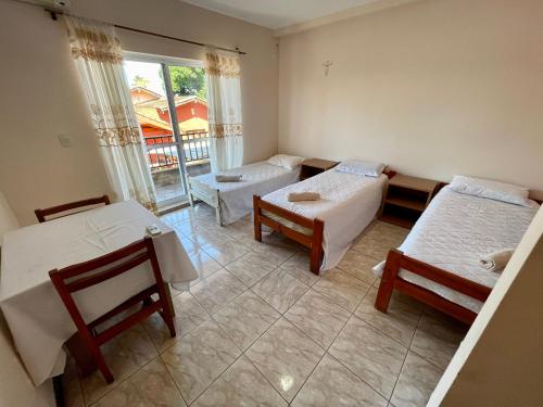 a room with two beds and a table and chairs at El Tata in Puerto Iguazú