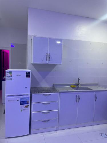 a kitchen with a white refrigerator and a sink at الجامعين ستار in Ruqaiqah