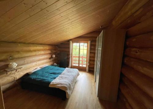 1 dormitorio en una cabaña de madera con 1 cama. en CHALET RONDIN en Gryon