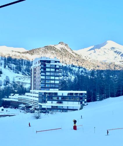 un bâtiment sur une piste de ski dans la neige dans l'établissement SKI AUX PIEDS, à Vars