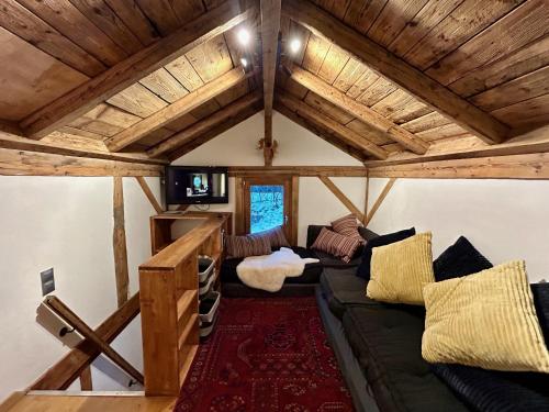 Gorgeous Mini-Chalet Chamonix في شامونيه مون بلان: غرفة معيشة مع أريكة وسقوف خشبي
