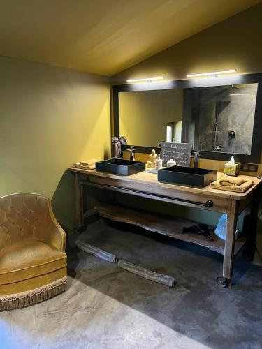 Le Clos de Mara في Issus: حمام مع مغسلتين وكرسي