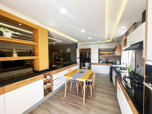 cocina con armarios blancos y mesa de madera en Log. standing complet 180 m2 en Sousse
