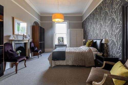 ein Schlafzimmer mit einem Bett und einem Kamin in der Unterkunft Spacious, Light-filled Central Period Apartment in Bath