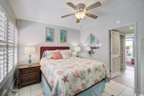 een slaapkamer met een bed en een plafondventilator bij Seaside Elegance Your Coastal Getaway in Myrtle Beach