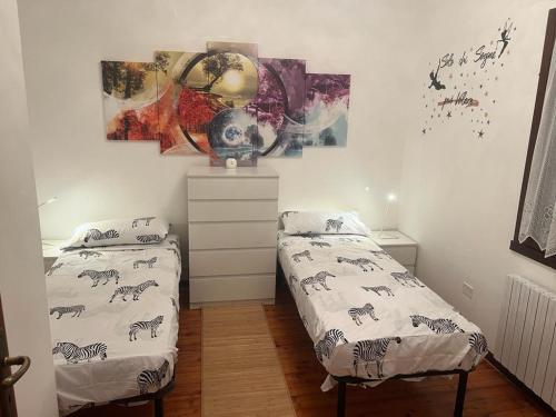 - une chambre avec 2 lits et un tableau mural dans l'établissement APPARTAMENTO PANORAMICO, à Treponti
