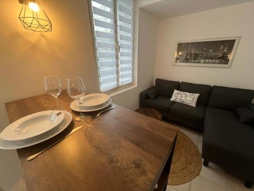 a living room with a wooden table with wine glasses at Le Duo de la Foret - Logement F1 in Sahurs