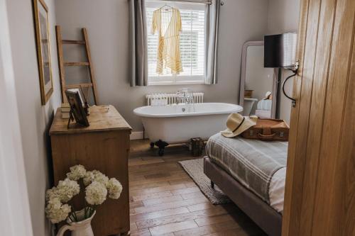 baño con bañera y ventana en Pinkmead Estate and Vineyard, en Osborne