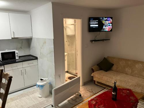 a small living room with a couch and a kitchen at Natalija-Sofija in Travnik