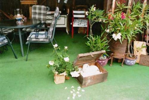 un jardín con flores, una mesa y una silla en Ferienhaus Hofmann Hainrode, 