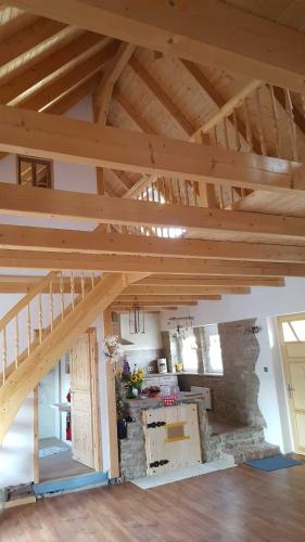 a large room with wooden ceilings and a stone wall at Ferienwohnung Jean Wallhausen in Wallhausen