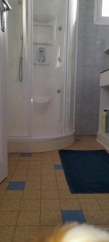 y baño con ducha y nevera blanca. en Mon gîte au Jura en Lavans-lès-Saint-Claude