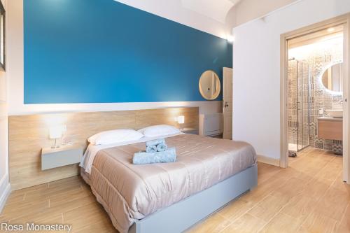 um quarto com uma cama com uma parede azul em Rosa Monastery em Nápoles