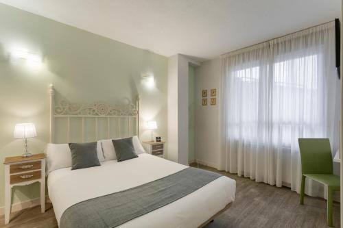 1 dormitorio con cama blanca y ventana en Alda Centro Zamora en Zamora