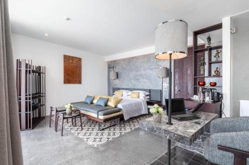 a bedroom with a bed and a living room at Hotel Vellita Siem reap in Siem Reap