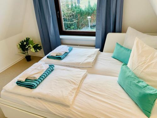 two beds with pillows on them in a bedroom at Kapitäns Hus 2 mit Infrarotsauna und großem Garten in Graal-Müritz