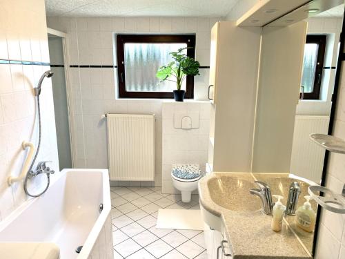 a bathroom with a tub and a sink and a toilet at Kapitäns Hus 2 mit Infrarotsauna und großem Garten in Graal-Müritz