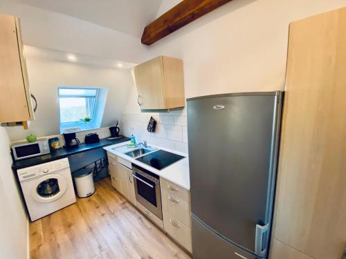a kitchen with a stainless steel refrigerator and a dishwasher at Apartment SCHLEUSENTOR - Ferienwohnung Maisonette in Rostock