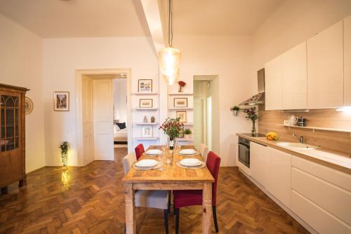 cocina con mesa de madera y sillas rojas en Apartman Iris, en Zagreb