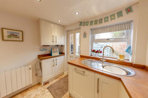 a kitchen with a sink and a window at Angel Cottage in Southwold